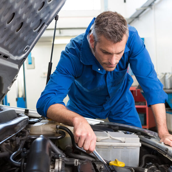 Technicien en réparation automobile – Élite Collision Laval Technicien effectuant une réparation dans un atelier de carrosserie à Laval chez Élite Collision.