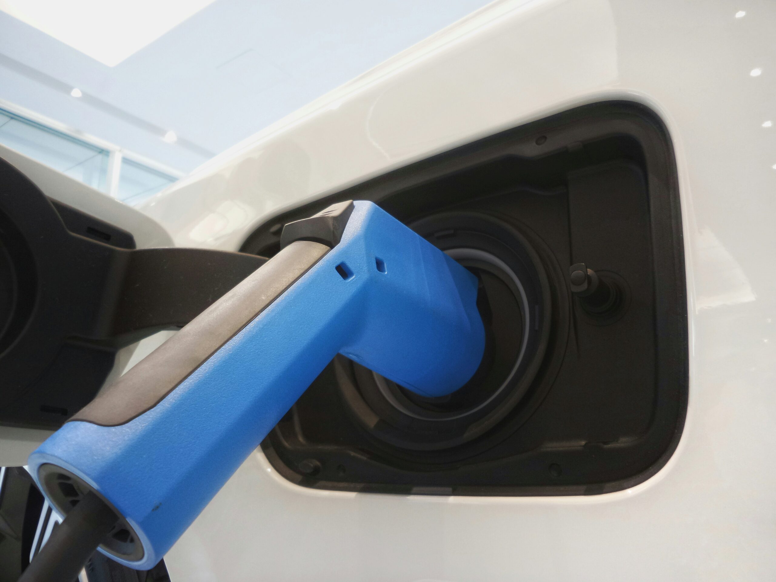 Recharge d’un véhicule électrique – Élite Collision Connecteur de recharge branché sur un véhicule électrique, illustrant l’expertise EV d’Élite Collision à Laval.